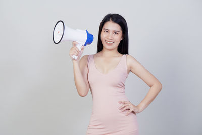 Portrait of smiling young woman against white background