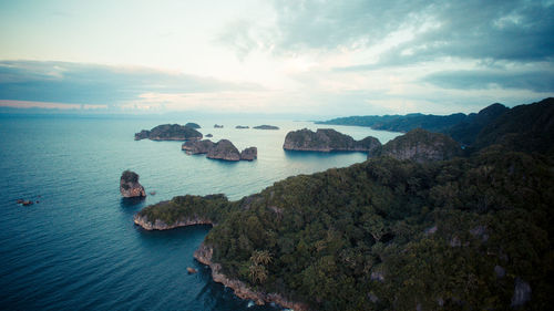 Scenic view of rocks in sea against sky