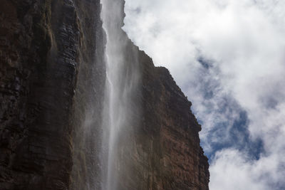 Low angle view of waterfall against sky