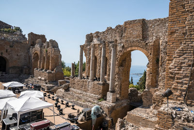 Columns at old ruins of ancient greek theater with blue sky in background