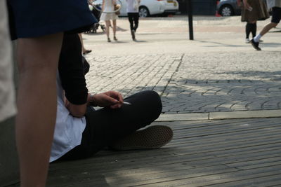 Low section of woman sitting outdoors