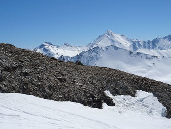 Scenic view of snowcapped mountains against clear blue sky