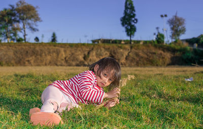 Portrait of boy playing with eyes closed lying on field