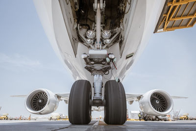 Low angle view of airplane on airport runway against sky