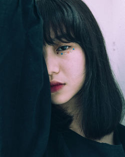 Close-up portrait of woman wearing stars under eye