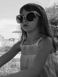 Girl wearing sunglasses while sitting outdoors