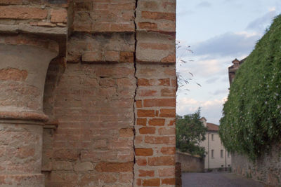 Brick wall against cloudy sky