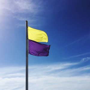 Low angle view of flag against blue sky