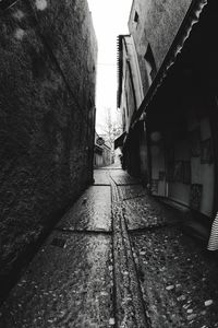 Walkway amidst buildings in city