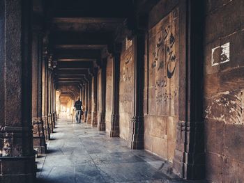 Rear view of person on colonnade in old building