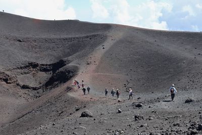 People on mountain road against sky