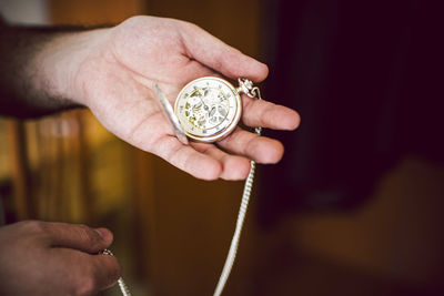 Close-up of hand holding pocket watch