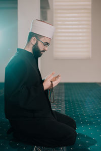 Side view of young man using mobile phone