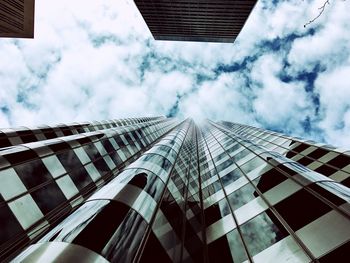 Directly below shot of modern building against cloudy sky