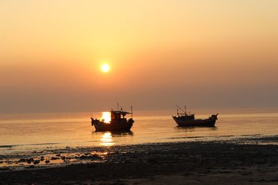 Silhouette boat on sea against sky during sunset