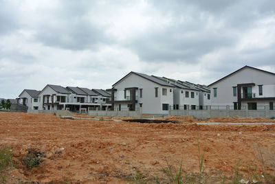 Houses on field against sky