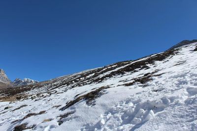 Snowcapped mountains against clear blue sky