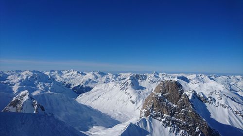 Scenic view of snow covered mountain against blue sky