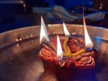 Close-up of lit candles on table