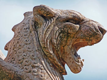 Low angle view of roaring lion statue against clear sky