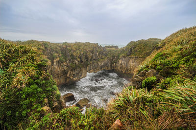 Scenic view of waterfall against sky