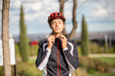 Portrait of man holding camera while standing outdoors