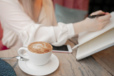 Midsection of coffee cup on table