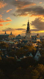 Buildings in city against sky during sunset