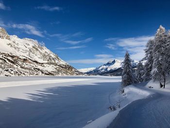 Scenic view of snowcapped mountains against blue sky