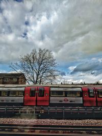 Train by railroad tracks against sky