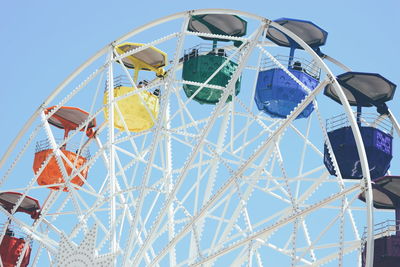 Low angle view of ferris wheel against clear blue sky