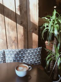 High angle view of coffee cup on wooden table in cafe