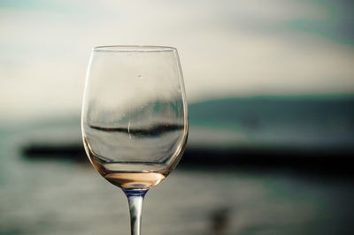 Close-up of wineglass against sky