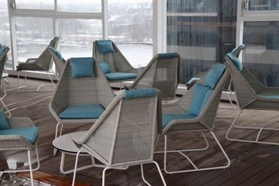 Empty chairs and tables in glass building