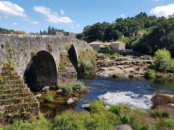 Arch bridge over river against sky