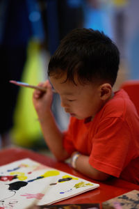 Boy painting at desk