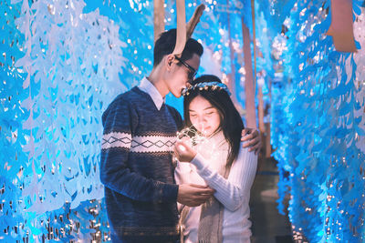 Young man with girlfriend holding illuminated lights