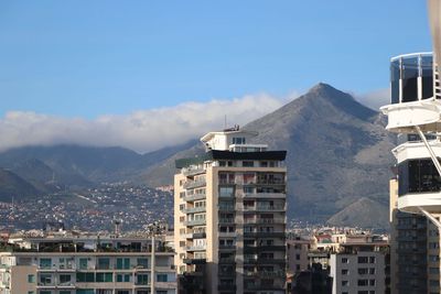 Buildings in city against cloudy sky