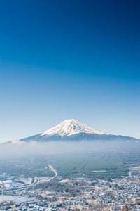 Scenic view of snowcapped mountains against clear blue sky