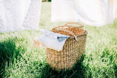 Wicker basket filled with bed linen in a yard at home in summer