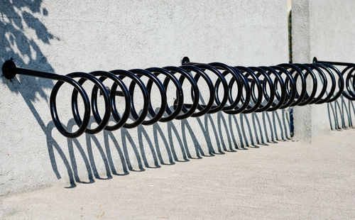 Metal railing on footpath against wall