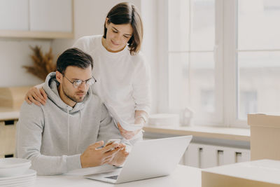 Couple using laptop phone