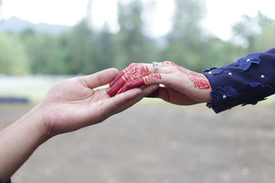 Close-up of cropped couple holding hands