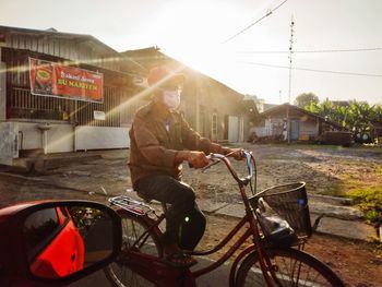 Man riding bicycle on street in city