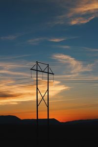 Silhouette electricity pylon against sky during sunset