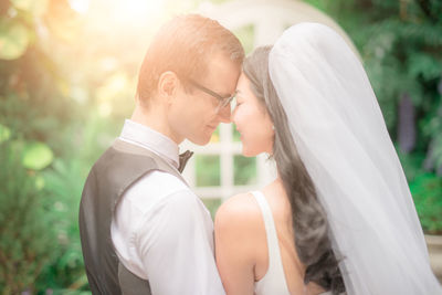 Loving wedding couple standing at backyard