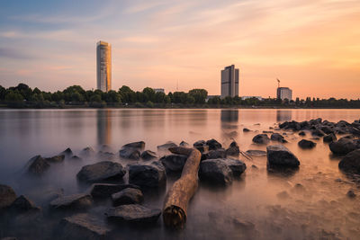 Rocks in city against sky during sunset