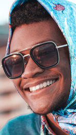 Close-up portrait of a smiling young man wearing sunglasses