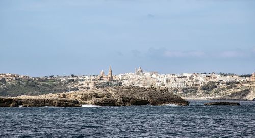 Panoramic view of sea and buildings against sky