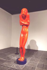 Statue on red floor against wall